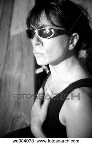 Close-up of a young woman, wearing sunglasses, sitting on empty bleachers at a fair View Large Photo Image Stock Photo - Close-up of a young woman, wearing sunglasses, sitting on empty bleachers at a fair. Fotosearch