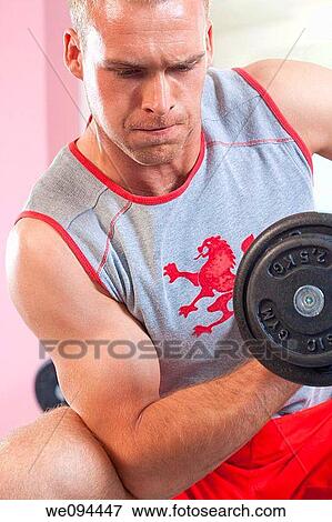 closeup of a young man exercising biceps with dumbbell in modern gym View Large Photo Image Stock Photo - closeup of a young man exercising biceps with dumbbell in modern gym. Fotosearch