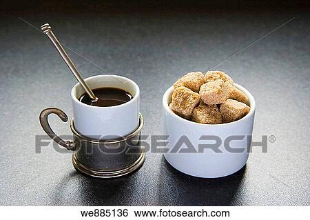 Stock Photograph - Cup of coffee and sugar cubes in white ceramic pot. Fotosearch