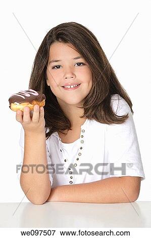 Cute Caucasian girl eating a donut on a white background View Large Photo Image Stock Photo - Cute Caucasian girl eating a donut on a white background. Fotosearch