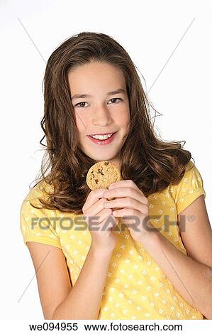 Stock Photography - Cute Caucasian girl eating Chocolate Chip Cookies. Fotosearch