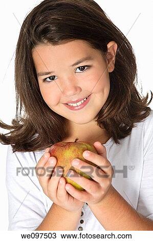Cute Caucasian girl happy about eating an apple View Large Photo Image Stock Image - Cute Caucasian girl happy about eating an apple. Fotosearch