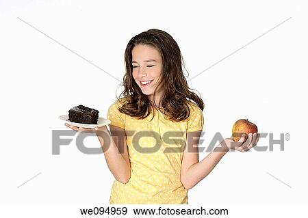 Cute Caucasian girl trying to make a decision between eating healthy or not View Large Photo Image Stock Photo - Cute Caucasian girl trying to make a decision between eating healthy or not. Fotosearch