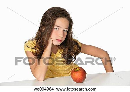 Cute Caucasian girl unhappy about eating an apple View Large Photo Image Picture - Cute Caucasian girl unhappy about eating an apple. Fotosearch