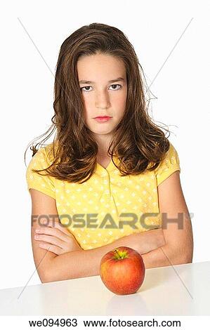Cute Caucasian girl unhappy about eating an apple View Large Photo Image Stock Image - Cute Caucasian girl unhappy about eating an apple. Fotosearch