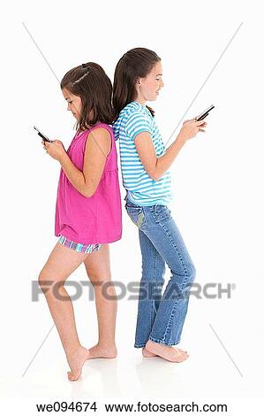 Cute Caucasian girls texting on a cell phone View Large Photo Image Picture - Cute Caucasian girls texting on a cell phone. Fotosearch