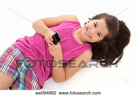 Stock Image - Cute Caucasian girls texting on a cell phone. Fotosearch