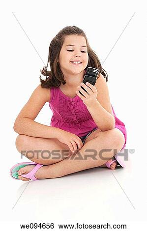 Stock Photograph - Cute Caucasian girls texting on a cell phone. Fotosearch