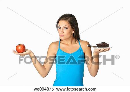 Cute Caucasian woman trying to make a decision between eating healthy or not View Large Photo Image Stock Photography - Cute Caucasian woman trying to make a decision between eating healthy or not. Fotosearch
