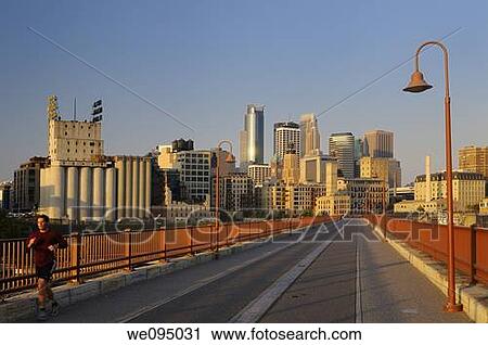 Early morning jogger and Minneapolis highrise tower skyline from the Stone Arch Bridge at sunrise View Large Photo Image Stock Image - Early morning jogger and Minneapolis highrise tower skyline from the Stone Arch Bridge at sunrise. Fotosearch