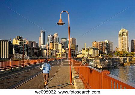 Early morning jogger and Minneapolis highrise towers and Lock and Dam 1 from the Stone Arch Bridge at sunrise View Large Photo Image Stock Image - Early morning jogger and Minneapolis highrise towers and Lock and Dam 1 from the Stone Arch Bridge at sunrise. Fotosearch