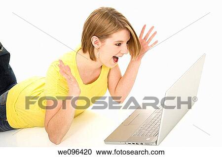 Excited Caucasian teenager woking on laptop computer View Large Photo Image Stock Image - Excited Caucasian teenager woking on laptop computer. Fotosearch