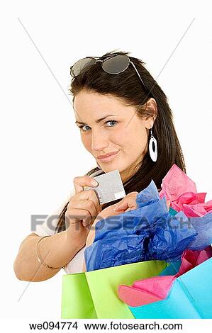 Excited Caucasian woman holding shopping bags and a credit card smiling on white background View Large Photo Image Picture - Excited Caucasian woman holding shopping bags and a credit card smiling on white background. Fotosearch