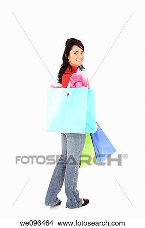 Excited Caucasian woman holding shopping bags and smiling on white background View Large Photo Image Picture - Excited Caucasian woman holding shopping bags and smiling on white background. Fotosearch