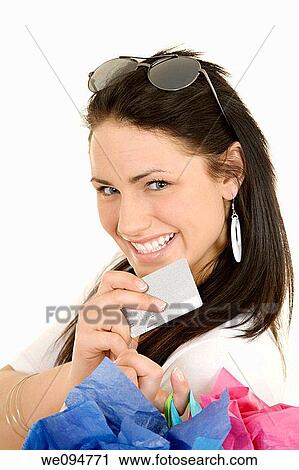 Excited Caucasian woman holding shopping bags and a credit card smiling on white background View Large Photo Image Stock Image - Excited Caucasian woman holding shopping bags and a credit card smiling on white background. Fotosearch