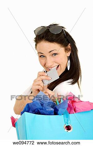 Excited Caucasian woman holding shopping bags and a credit card smiling on white background View Large Photo Image Stock Image - Excited Caucasian woman holding shopping bags and a credit card smiling on white background. Fotosearch