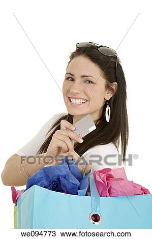 Excited Caucasian woman holding shopping bags and a credit card smiling on white background View Large Photo Image Stock Image - Excited Caucasian woman holding shopping bags and a credit card smiling on white background. Fotosearch