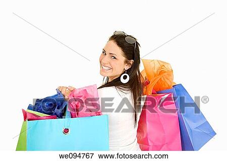 Excited Caucasian woman holding shopping bags and smiling on white background View Large Photo Image Stock Photo - Excited Caucasian woman holding shopping bags and smiling on white background. Fotosearch
