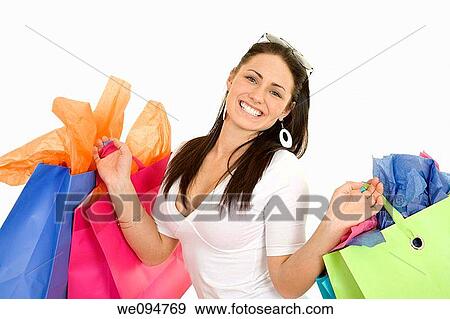 Excited Caucasian woman holding shopping bags and smiling on white background View Large Photo Image Stock Photo - Excited Caucasian woman holding shopping bags and smiling on white background. Fotosearch