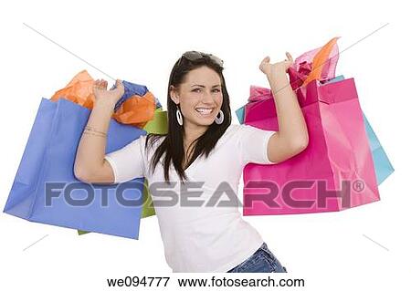 Stock Photo - Excited Caucasian woman holding shopping bags and smiling on white background. Fotosearch