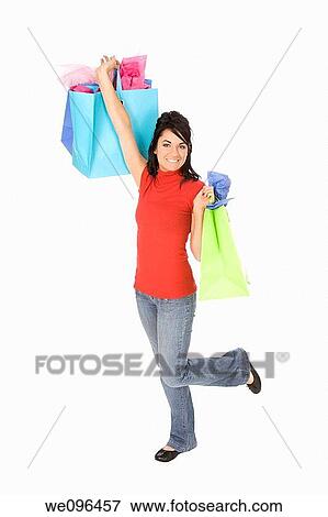 Excited Caucasian woman holding shopping bags and smiling on white background View Large Photo Image Stock Photo - Excited Caucasian woman holding shopping bags and smiling on white background. Fotosearch