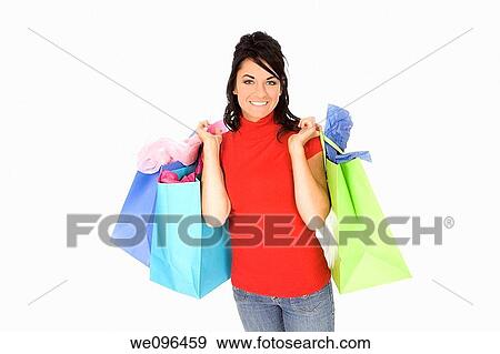 Excited Caucasian woman holding shopping bags and smiling on white background View Large Photo Image Stock Photo - Excited Caucasian woman holding shopping bags and smiling on white background. Fotosearch