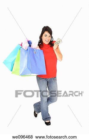 Excited Caucasian woman holding shopping bags and smiling on white background View Large Photo Image Stock Photo - Excited Caucasian woman holding shopping bags and smiling on white background. Fotosearch
