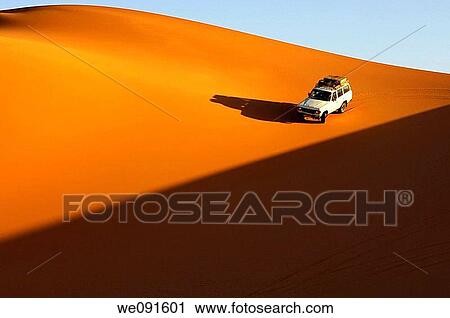 Four-wheel drive car driving at sunset on the pristine slope of a sand dune in the Erg Muzuruq of the Sahara desert, Libya View Large Photo Image Stock Image - Four-wheel drive car driving at sunset on the pristine slope of a sand dune in the Erg Muzuruq of the Sahara desert, Libya. Fotosearch