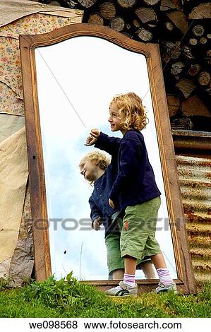 Four years old girl playing around a big mirror reflecting the blue sky View Large Photo Image Stock Photo - Four years old girl playing around a big mirror reflecting the blue sky. Fotosearch