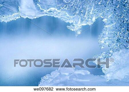 Stock Image - frozen creek with water flowing, detail. Fotosearch