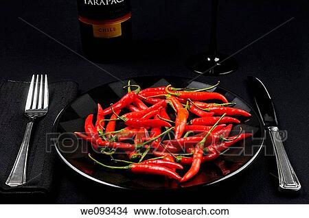 Full plate of red hot Chili Peppers at a black table setting with wine from Chile View Large Photo Image Picture - Full plate of red hot Chili Peppers at a black table setting with wine from Chile. Fotosearch