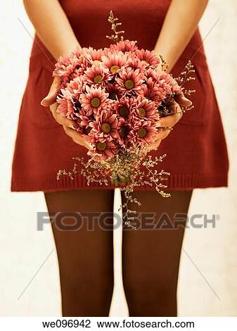 Good-looking young woman in a red dress holding a flower bouquet View Large Photo Image Stock Image - Good-looking young woman in a red dress holding a flower bouquet. Fotosearch
