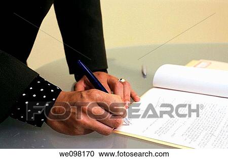 Stock Image - Hands of a business woman signing a contract. Fotosearch
