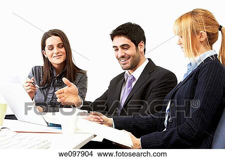 Happy business people in a meeting working on a laptop View Large Photo Image Picture - Happy business people in a meeting working on a laptop. Fotosearch