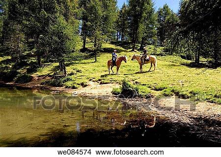 Horseback trail riding by Prese little lake from Serot horsemen lodge, Lagorai mountain range, Trentino, Italy View Large Photo Image Picture - Horseback trail riding by Prese little lake from Serot horsemen lodge, Lagorai mountain range, Trentino, Italy. Fotosearch