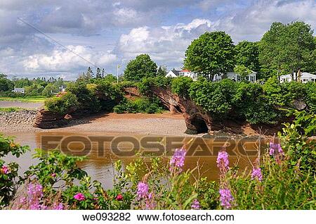Stock Image - Houses over the sea caves and arches on the shores of St Martins New Brunswick. Fotosearch