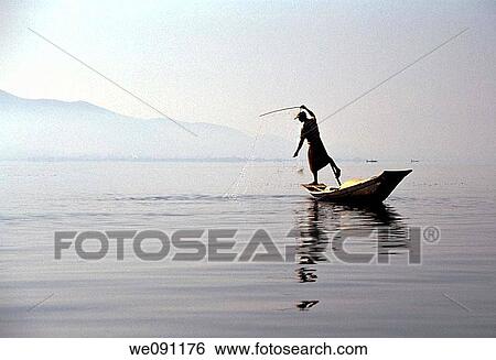 Stock Photograph - Inle Lake, Myanmar A classical picture of Inle Lake's famed? leg-rowing? fisherman This shows it all: the fisherman standing at the stern of the ship, who paddles with his leg wrapped around the oar so he can get a better view of fish below the clear la. Fotosearch