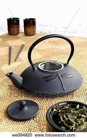 Stock Image - Japanese cast iron teapot with tea leaves on a cold winter day. Fotosearch