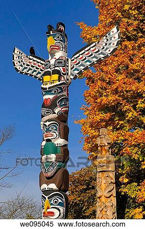 Kakasolas and Beaver Crest totem poles in Stanley Park Vancouver with raven on blue sky and Fall leaves View Large Photo Image Stock Photography - Kakasolas and Beaver Crest totem poles in Stanley Park Vancouver with raven on blue sky and Fall leaves. Fotosearch