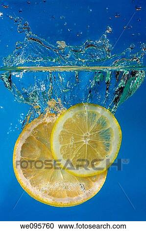 Lemon and grapefruit slices splashing into water with a blue background View Large Photo Image Stock Image - Lemon and grapefruit slices splashing into water with a blue background. Fotosearch