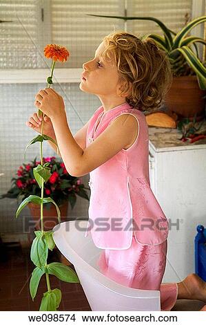 Little girl and her tall flower on the balcony View Large Photo Image Picture - Little girl and her tall flower on the balcony. Fotosearch