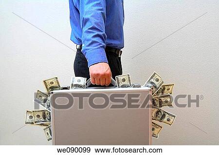 Stock Photo - Man Holding Briefcase with Money Sticking Out. Fotosearch