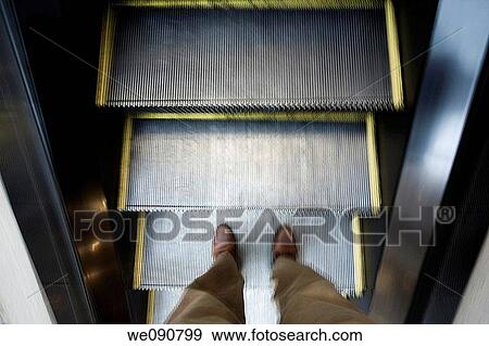 Man's feet as he goes on an up escalator View Large Photo Image Stock Photo - Man's feet as he goes on an up escalator. Fotosearch