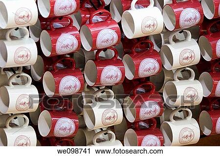 Stock Image - Many red and white mugs with Stanford University logo hanging from a rack in a display at the college bookstore in Stanford, California. Fotosearch
