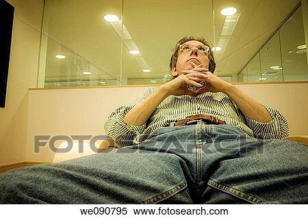 Middle-age man, wearing glasses, sitting in an office building lobby View Large Photo Image Stock Photography - Middle-age man, wearing glasses, sitting in an office building lobby. Fotosearch