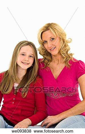 Mother and daughter setting on a white background together in casual clothing View Large Photo Image Stock Photo - Mother and daughter setting on a white background together in casual clothing. Fotosearch