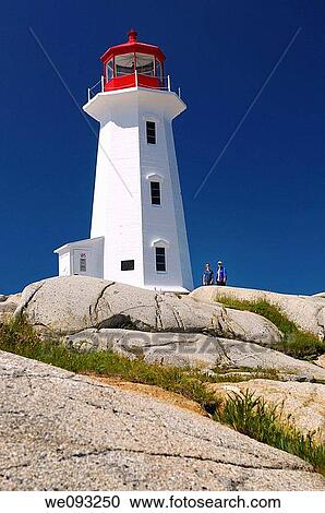 Peggys Cove white lighthouse against a blue sky with mother and daughter tourists View Large Photo Image Stock Image - Peggys Cove white lighthouse against a blue sky with mother and daughter tourists. Fotosearch