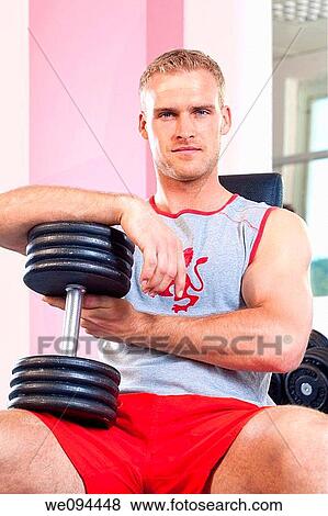portrait of a young man holding dumbbells in modern gym View Large Photo Image Stock Photo - portrait of a young man holding dumbbells in modern gym. Fotosearch