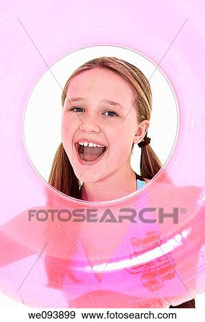 Preteen caucasian girl acting silly on a white background in a swimsuit holdng a beach toy and smiling View Large Photo Image Stock Photo - Preteen caucasian girl acting silly on a white background in a swimsuit holdng a beach toy and smiling. Fotosearch