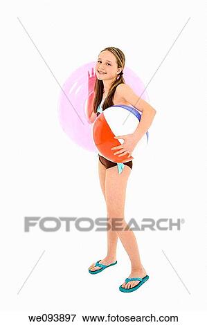 Preteen caucasian girl standing on a white background in a swimsuit holding a beach toy and smiling View Large Photo Image Stock Photo - Preteen caucasian girl standing on a white background in a swimsuit holding a beach toy and smiling. Fotosearch
